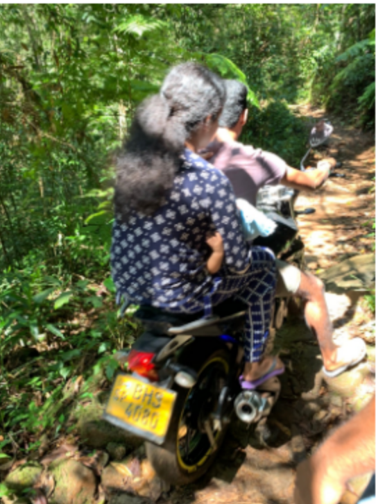 バイクでシンハラージャ森林保護区を往来する人々
